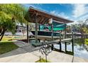 Covered boat dock featuring a platform and lift for easy water access at 7256 Westwind St, Weeki Wachee, FL 34607