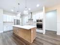Spacious kitchen with a large island, stainless steel appliances, and modern pendant lighting at 9065 Mississippi Run, Weeki Wachee, FL 34613