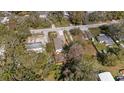 An aerial view of the property reveals a fenced yard, gravel driveway, and cozy home in the neighborhood at 9250 Peony St, New Port Richey, FL 34654