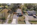 An aerial view of the property reveals a fenced yard, gravel driveway, and cozy home at 9250 Peony St, New Port Richey, FL 34654