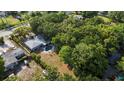 Aerial view of the home with a pool, patio, lush greenery, and spacious backyard surrounded by mature trees at 1101 N Betty Ln, Clearwater, FL 33755