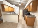 Functional kitchen featuring neutral tile floors, wood cabinets, stainless steel appliances and eat in counter at 11204 Clear Oak Cir, New Port Richey, FL 34654