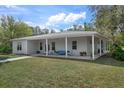 Charming single-story home with a metal roof, a covered porch, and manicured front lawn at 16411 County Road 675, Parrish, FL 34219