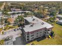 Exterior view of a multi-story residential building with a parking area and well-maintained landscaping at 1723 Gulf Rd # 104, Tarpon Springs, FL 34689