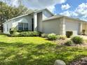 Beautiful single Gathering home with green lawn and well manicured landscaping at 18030 Webster Grove Dr, Hudson, FL 34667