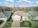 An aerial view of a single-Gathering home with a well-maintained lawn, landscaping and a two car garage at 18629 Coastal Shore Ter, Land O Lakes, FL 34638