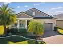 Charming home featuring a well-manicured lawn and a welcoming front porch, with a two-car garage at 19504 Lily Pond Ct, Brooksville, FL 34601