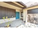 Inviting front porch area with a double blue front door, brick accent and attached garage at 2101 Sunset Point Rd # 2706, Clearwater, FL 33765