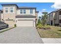 Inviting townhome showcases a paved driveway, lush lawn, and attached two-car garage at 29917 Southwell Ln, Wesley Chapel, FL 33543