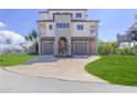 Beautiful three-story home with a two-car garage, arched entryway, and well-manicured lawn at 3073 Gulf Winds Cir, Hernando Beach, FL 34607