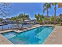 Gorgeous pool area with sparkling water and tropical landscaping, perfect for relaxation at 3073 Gulf Winds Cir, Hernando Beach, FL 34607