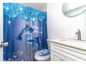 Bright bathroom featuring a dolphin-themed shower curtain and a sleek white vanity at 3542 Connon Dr, New Port Richey, FL 34652