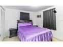 Cozy bedroom with a comfortable bed, soft purple bedding, and black bedside tables at 3542 Connon Dr, New Port Richey, FL 34652