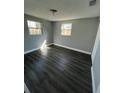 Bedroom with dark floors, neutral paint, and two windows at 5023 Queen Palm Dr, New Port Richey, FL 34652