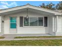 View of the front porch featuring a white brick facade and stylish outdoor lighting at 5122 Bonito Dr, New Port Richey, FL 34652