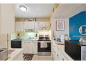 Cozy kitchen features white cabinets, stainless steel appliances, and an abundance of counter space at 6002 Laketree Ln # L, Temple Terrace, FL 33617
