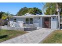 Inviting home exterior featuring stone accents, a manicured lawn, and a welcoming paved walkway at 7235 Maryland Ave, Hudson, FL 34667