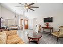 Bright living room with vaulted ceilings, gray wood floors, elegant furnishings, and plenty of natural light at 7514 Rocky Point Dr, Hudson, FL 34667