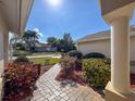 Front porch view showcasing a well-manicured walkway, beautiful landscaping, and a welcoming facade at 8447 Pavilion Dr, Hudson, FL 34667