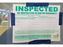 Pinellas County Inspection Notice for a residential home posted on a window taped with blue painter's tape at 103 Carlyle Dr, Palm Harbor, FL 34683