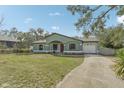 Exterior front view of light-green house with front lawn, red door, and attached garage at 13083 Jaywalk Rd, Brooksville, FL 34614