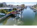 A waterfront view of a cozy home, featuring a private boat dock and access to serene canal waters at 13603 Jennita Dr, Hudson, FL 34667