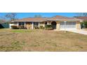 Charming single-story home featuring a well-maintained lawn and a two-car garage, perfect for suburban living at 2013 Meredith Dr, Spring Hill, FL 34608