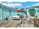 Inviting turquoise home featuring an outdoor patio with seating, perfect for enjoying the weather at 2334 Gimlet, Spring Hill, FL 34608