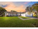Spacious kitchen with white cabinetry, modern appliances, a center island, and stylish flooring at 2862 Lomond Dr, Palm Harbor, FL 34684
