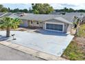 A charming single-story home, with an extended driveway leading to a garage, surrounded by a well-maintained yard at 3736 Sail Dr, New Port Richey, FL 34652