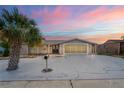 Charming single-story home with palm tree, gray accent, and a spacious driveway leading to a screened-in two-car garage at dusk at 3736 Sail Dr, New Port Richey, FL 34652