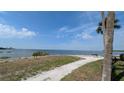 Scenic waterfront view of the bay with blue water and a waterfront walkway to a bench at 5000 Culbreath Key Way # 9-221, Tampa, FL 33611