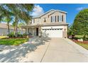 Charming two-story home featuring a well-maintained lawn, a two-car garage, and a welcoming front porch at 5412 Hammock View Ln, Apollo Beach, FL 33572