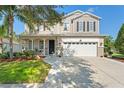 Charming two-story home featuring a well-maintained lawn, a two-car garage, and a welcoming front porch at 5412 Hammock View Ln, Apollo Beach, FL 33572