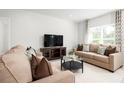 Cozy living room featuring neutral paint, plush sofas, modern decor, and a large bright window at 625 171St E St, Bradenton, FL 34212