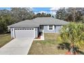 Charming single-story home featuring a well-manicured lawn, attached garage, and inviting curb appeal at 7399 Skylark Dr, Spring Hill, FL 34606