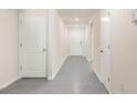 Clean, modern hallway with multiple doors, fresh paint, and tile flooring at 7552 Gardner St, Brooksville, FL 34613