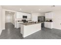 Modern open-concept kitchen featuring granite countertops, stainless steel appliances, and white cabinets at 7552 Gardner St, Brooksville, FL 34613