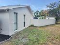 Side exterior with a privacy wall and green space at 8055 River Country Dr, Weeki Wachee, FL 34607