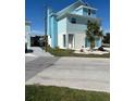 Two-story home features a light blue exterior, landscaped front yard and attached two-car garage at 6613 Josie Ln, Hudson, FL 34667