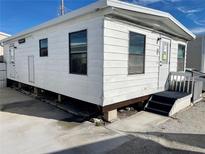 White single-wide mobile home with steps and a small yard at 3710 Gulf Of Mexico Dr # E3, Longboat Key, FL 34228