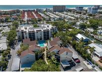 Beautiful aerial view of a condo community with a pool, carport, and lush greenery near the beach at 6157 Midnight Pass Rd # C11, Sarasota, FL 34242