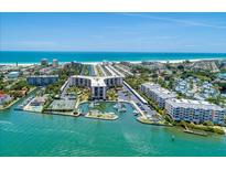 Aerial view of waterfront property with tennis courts and a marina at 5855 Midnight Pass Rd # 416, Sarasota, FL 34242
