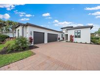 White modern home with three-car garage and paver driveway at 3739 Caledonia Ln, Sarasota, FL 34240