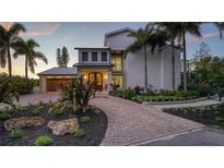 Stunning two-story home with a modern design, landscaped grounds, and a brick paved driveway at 6934 Belgrave Dr, Sarasota, FL 34242