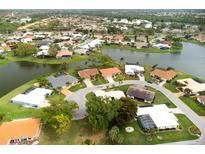 Aerial view of a single-story house on a waterfront lot in a residential community at 1654 Waxwing Ct, Venice, FL 34293