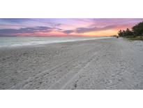 Scenic beach view with a colorful sunset sky and calm ocean water at 5005 Gulf Of Mexico Dr # 5, Longboat Key, FL 34228