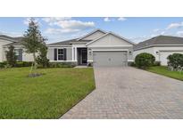 House exterior featuring a two-car garage and well-manicured lawn at 19642 Fort King Run, Brooksville, FL 34601