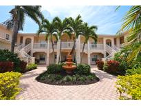 Two-story building with lush landscaping and a central fountain at 4264 Central Sarasota Pkwy # 116, Sarasota, FL 34238