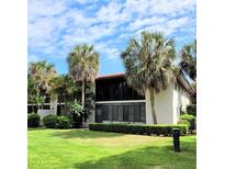 Two-story condo building with lush landscaping and a manicured lawn at 3500 El Conquistador Pkwy # 142, Bradenton, FL 34210